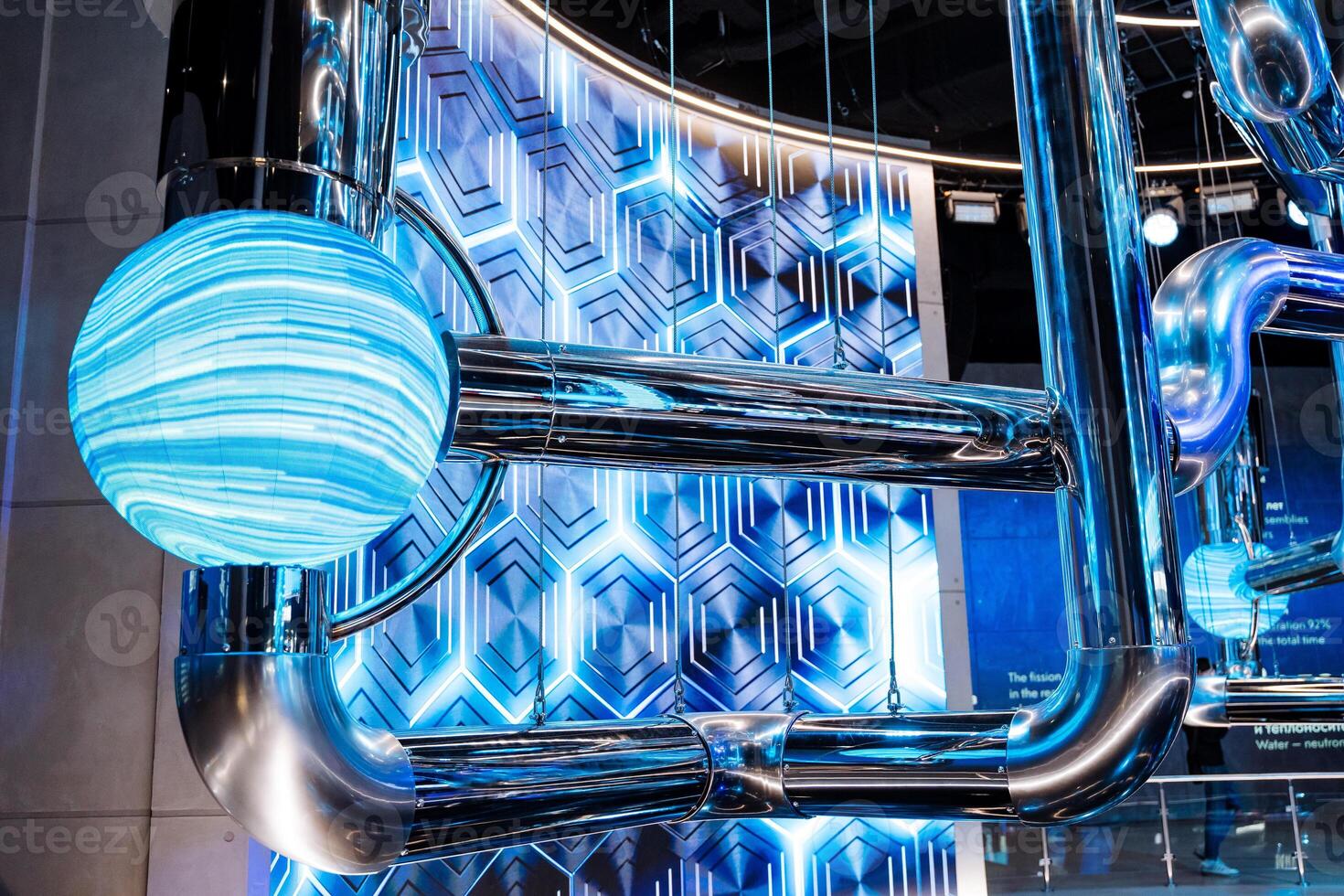 A blue automotive tire is suspended from the ceiling of a building photo