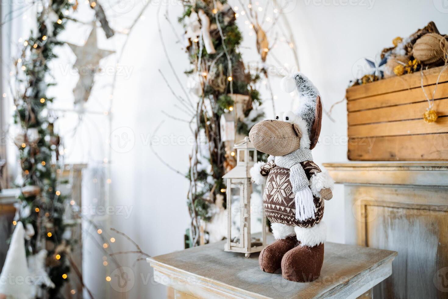 A stuffed animal is sitting on a table in front of a christmas tree photo