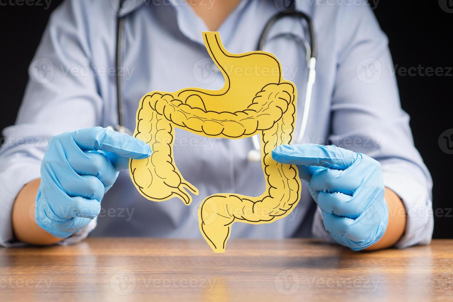 Doctor holding a large intestine shape made from yellow paper photo
