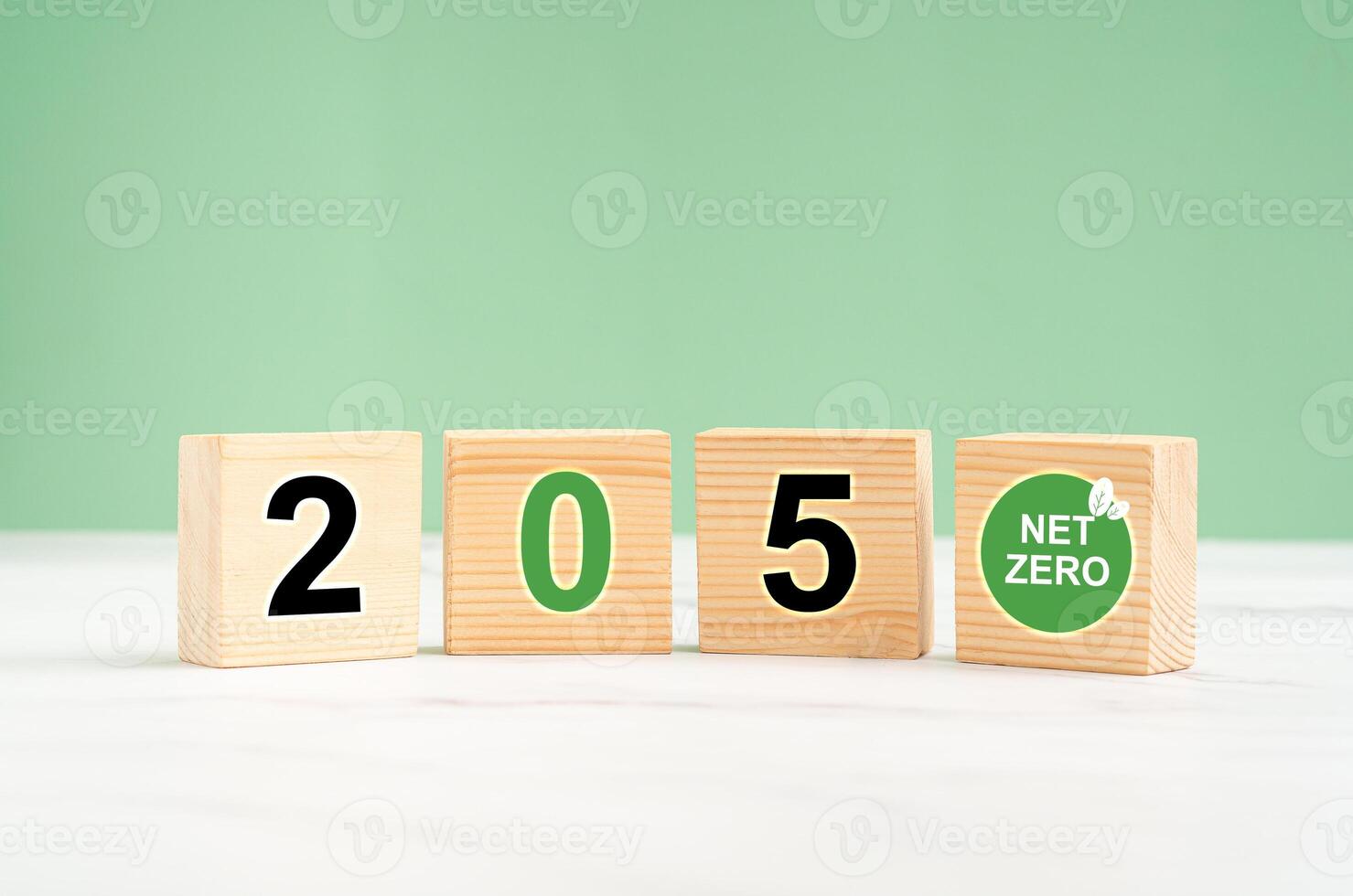 Net-zero greenhouse gas emissions in 2050 target. Wooden cubes with green icons against a light green background photo