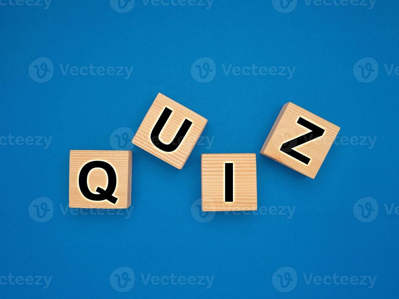 Wooden cubes with the letters QUIZ on a blue background photo