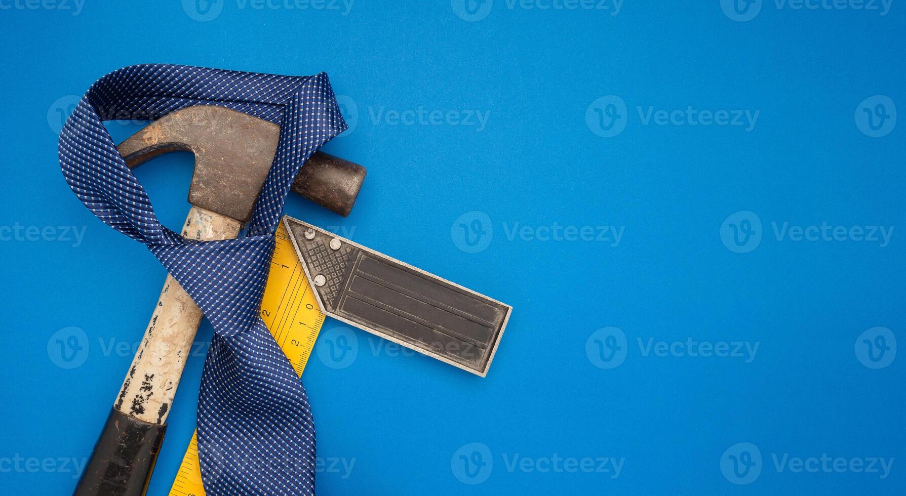 Happy Father's Day. Top view of construction handy tools and necktie over a blue background photo