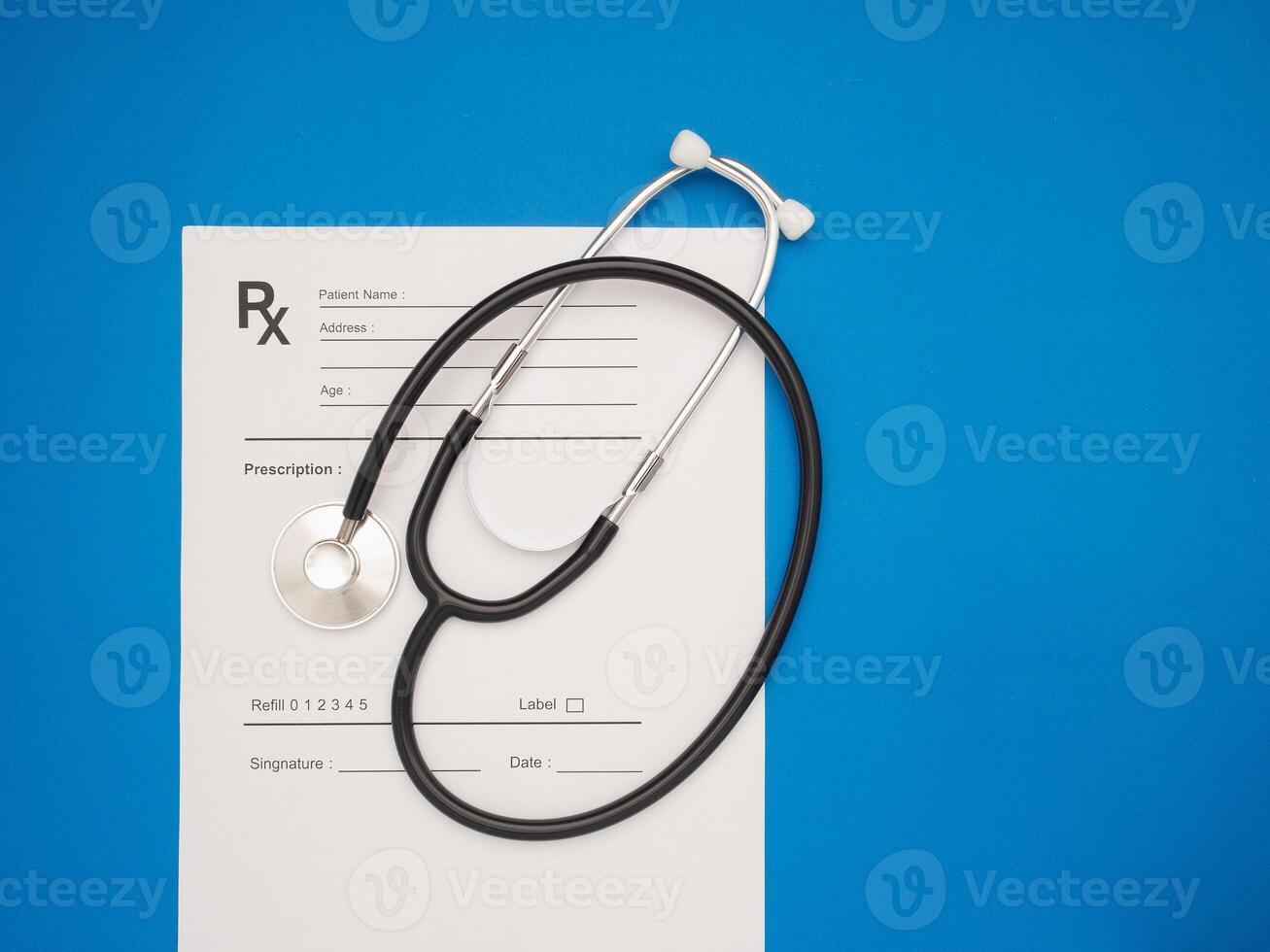 Top view of a stethoscope over the medical prescription sheet on a blue background photo