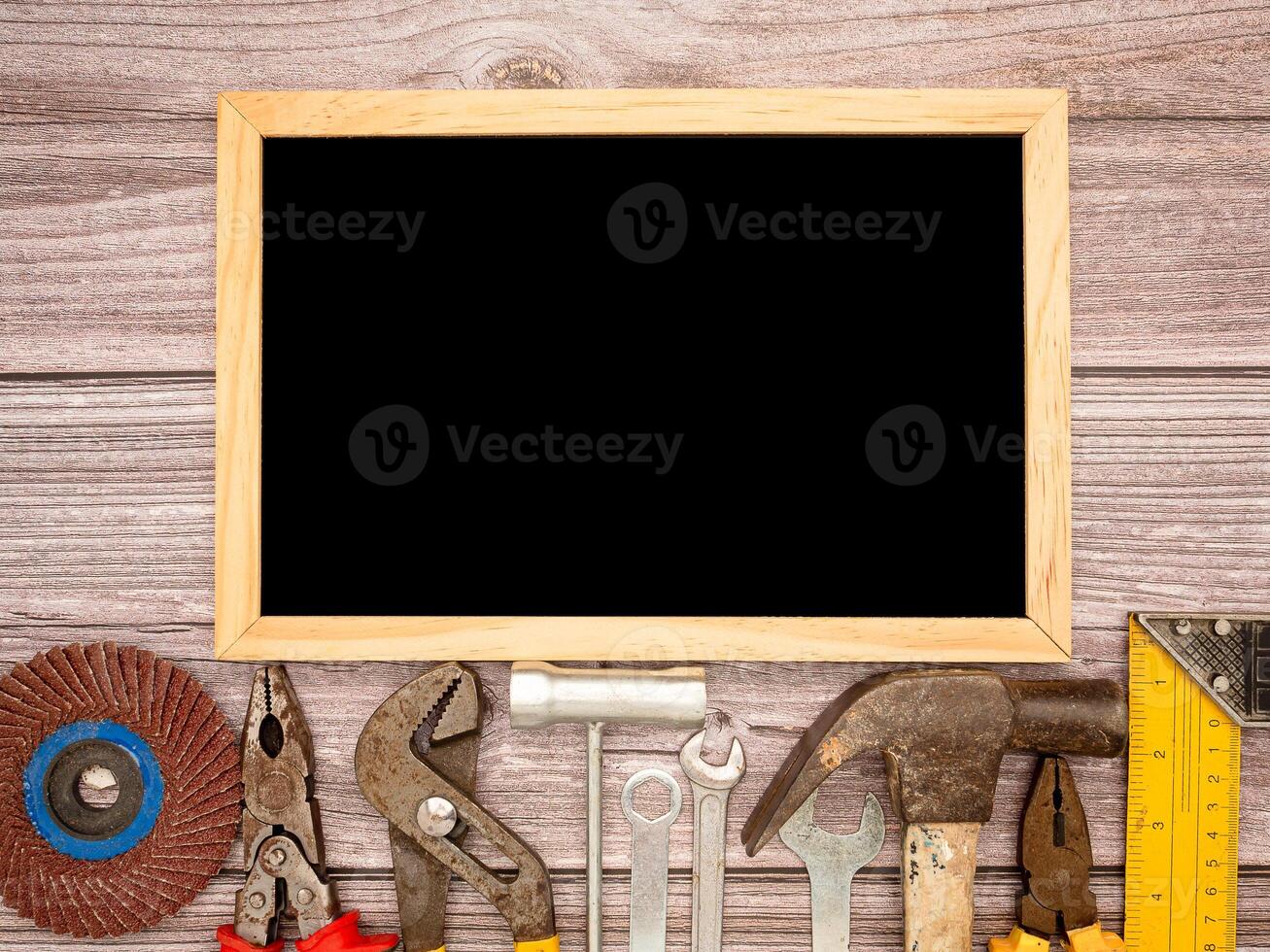 A blank mini chalkboard and construction tools on a wooden table photo
