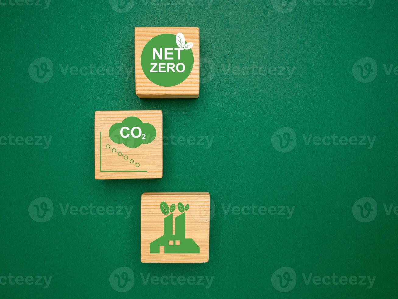Net-zero greenhouse gas emissions target. Wooden cubes with green icons over a green background photo