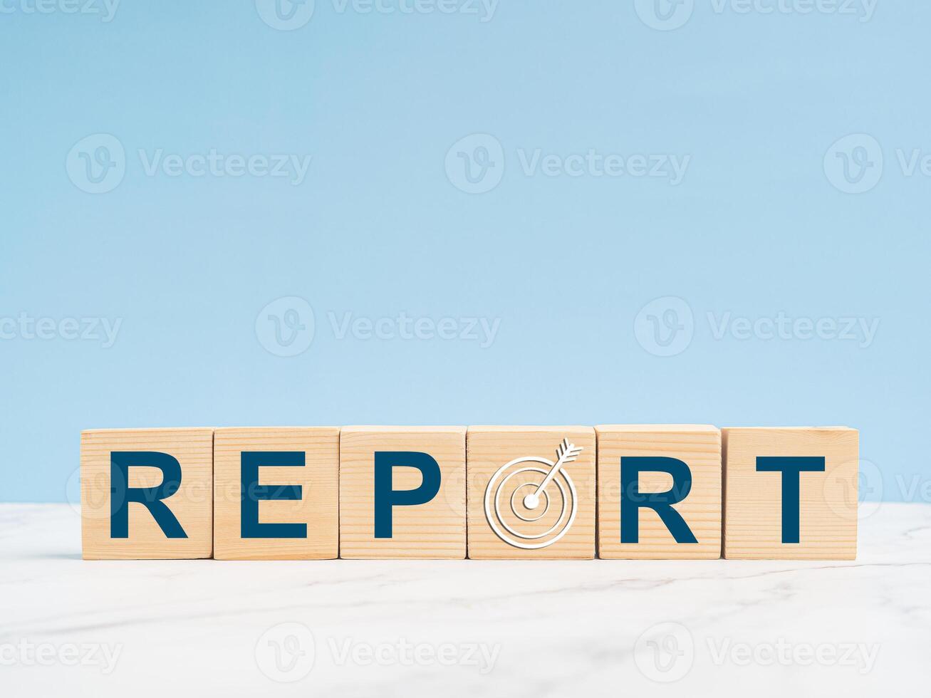Letters REPORT and target icon on wooden cubes over a marble floor with light blue background photo