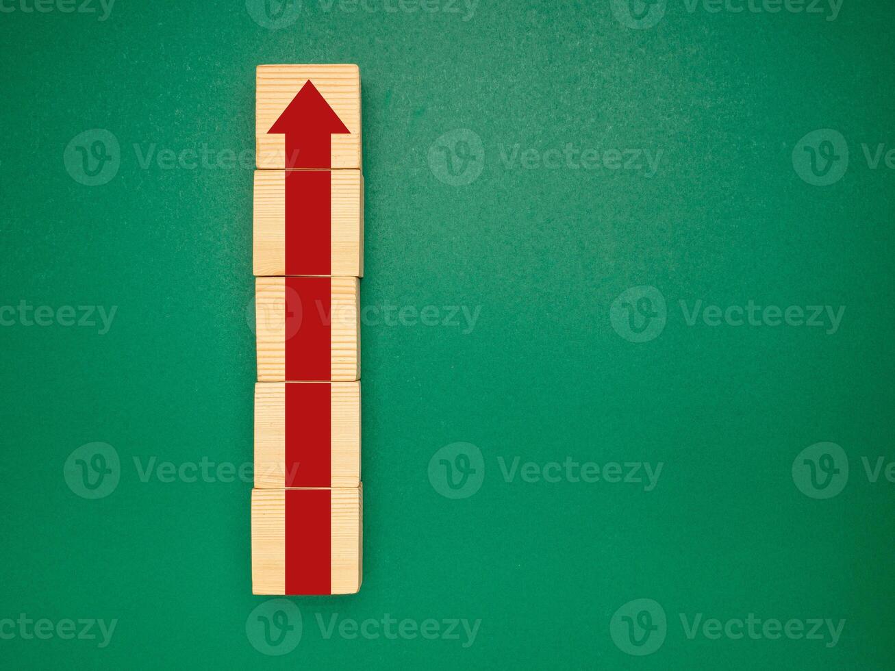 Wooden cubes with red arrows up over a green background. Business growth and strategy concept photo