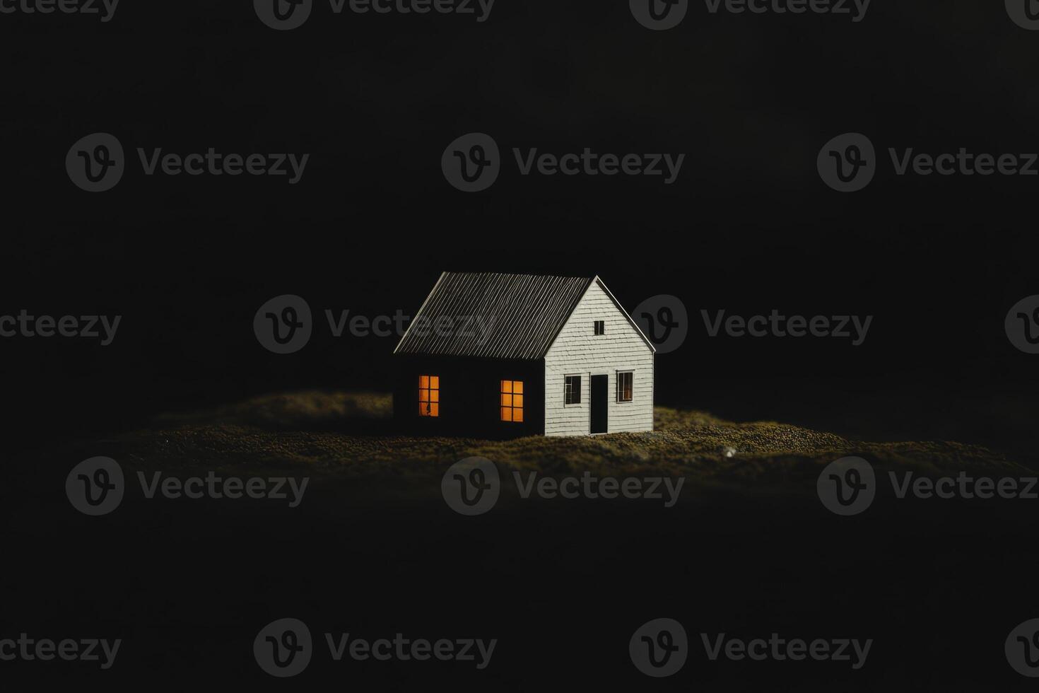 A small house is lit up with a light inside photo