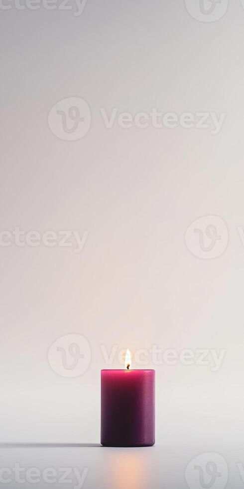 Minimalist Image of a Single Lit Purple Candle Against a Soft Gray Background photo