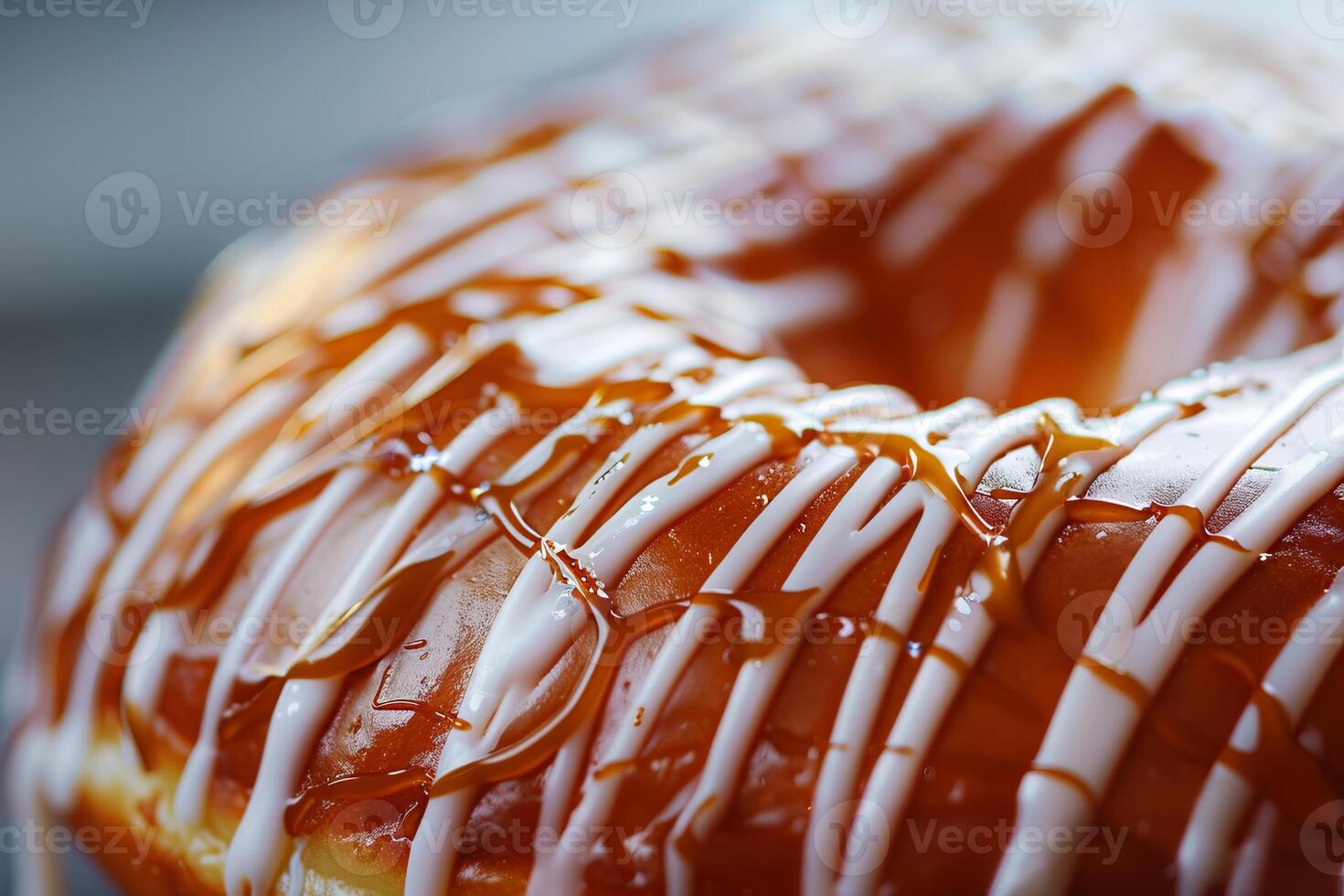 Close-Up of a Delicious Glazed Doughnut with Caramel and White Icing Drizzles photo