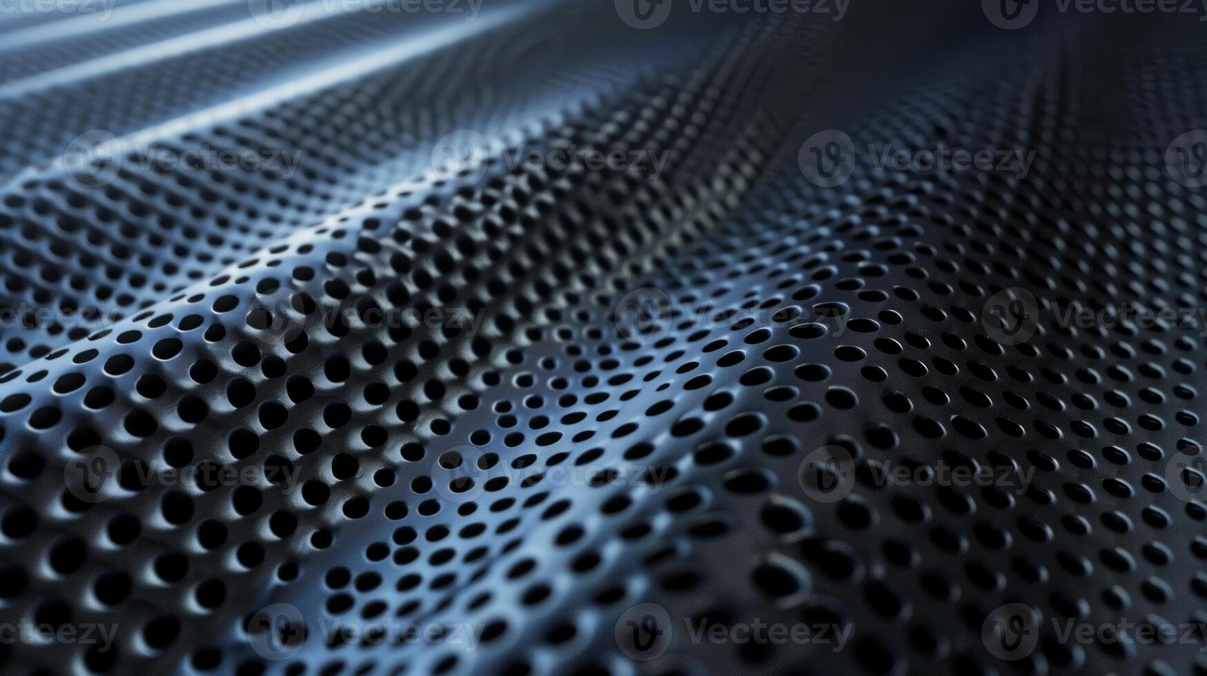 A close up of a black metal surface with many small holes photo