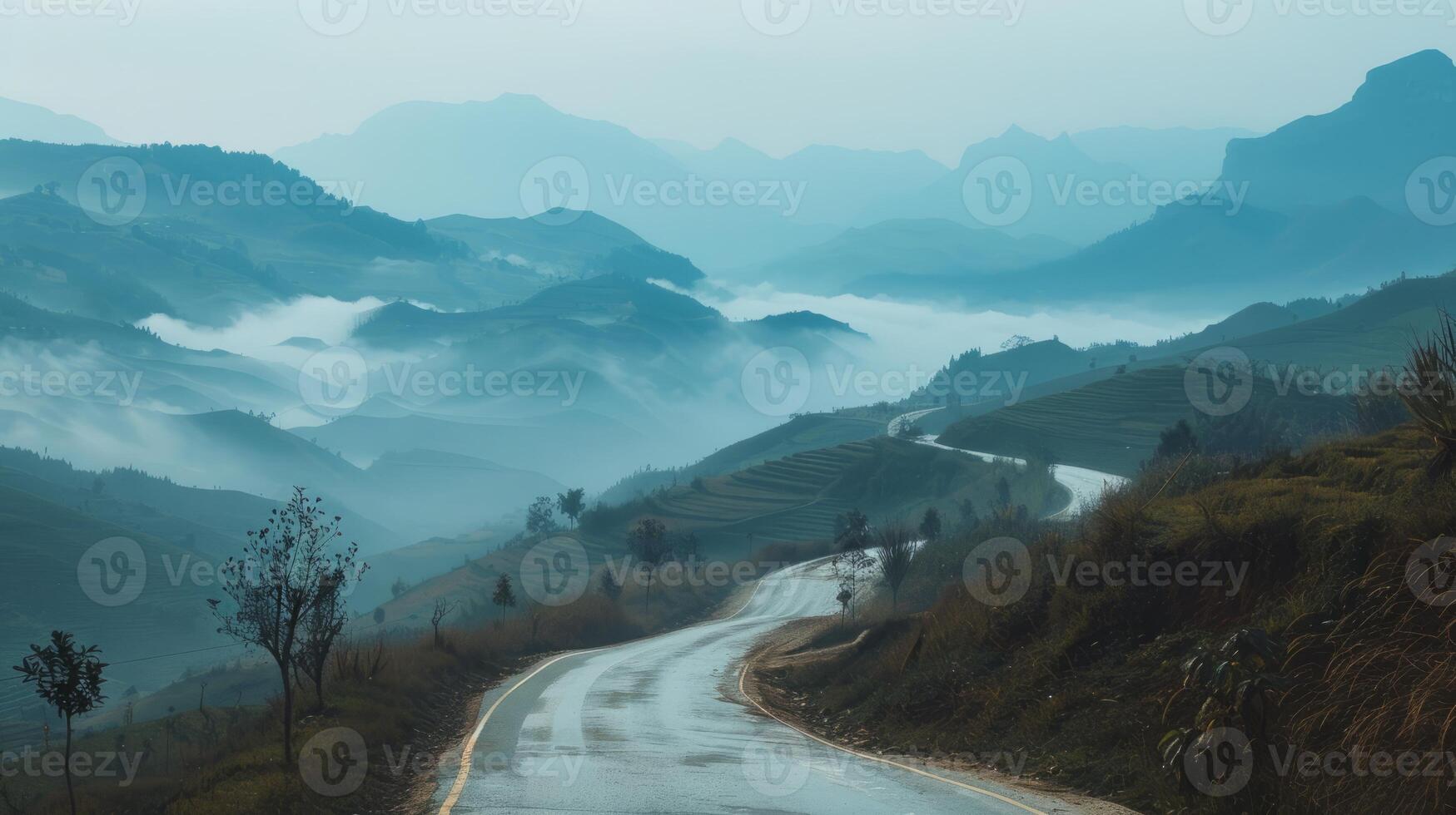 Copy space with a winding road through misty mountains photo