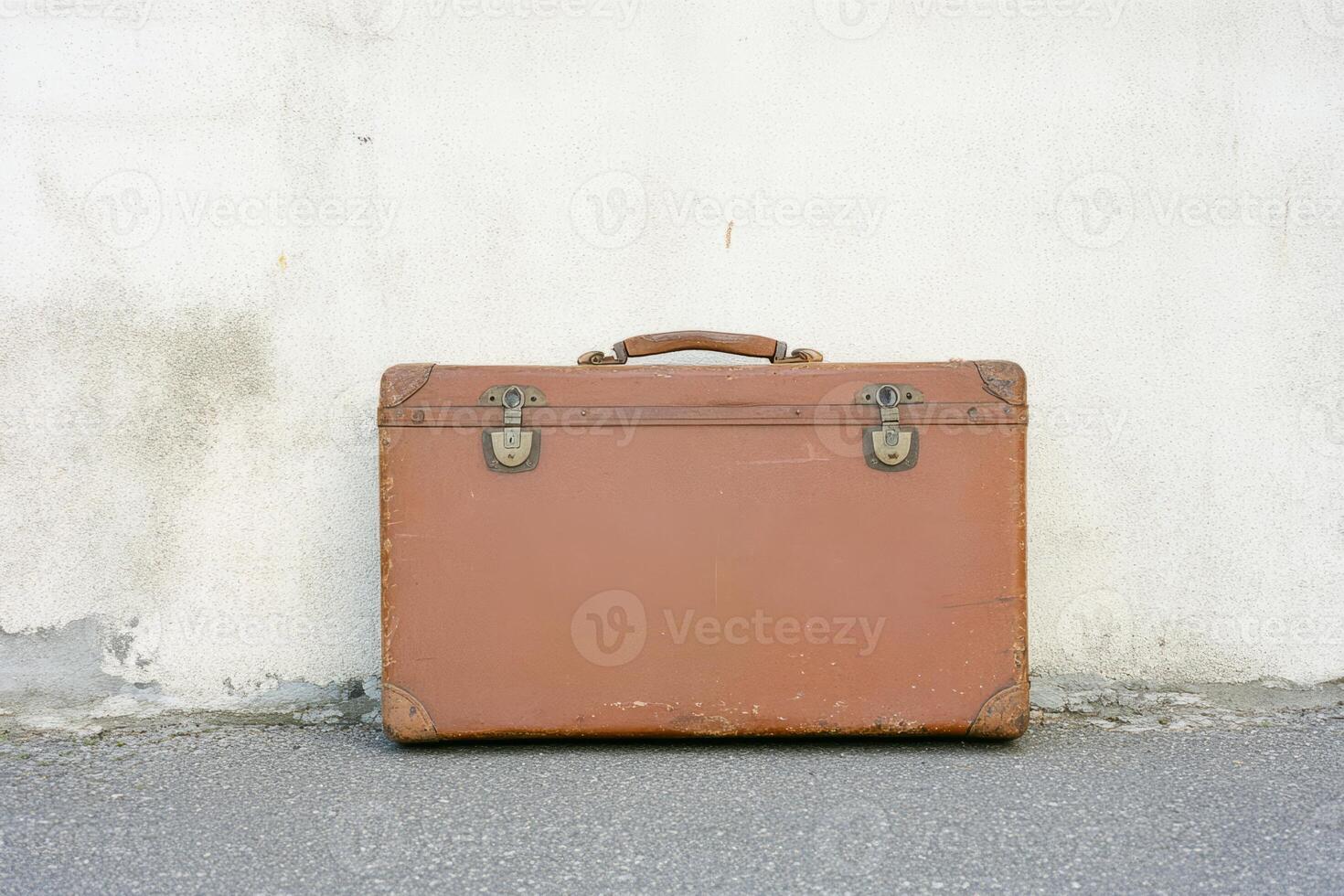 Vintage Leather Suitcase Against Weathered Wall Evoking Nostalgia and Adventure photo