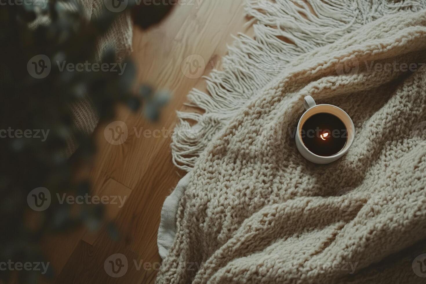 Cozy Morning Scene with a Warm Knit Blanket and Coffee Cup on Wooden Floor in Soft Natural Light photo