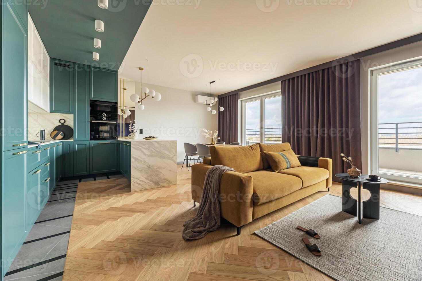 Creative and modern vintage open space interior design with yellow sofa and turquoise kitchen with a marble island. Grey carpet on the herringbone parquet with coffee table, brown curtain in windows. photo