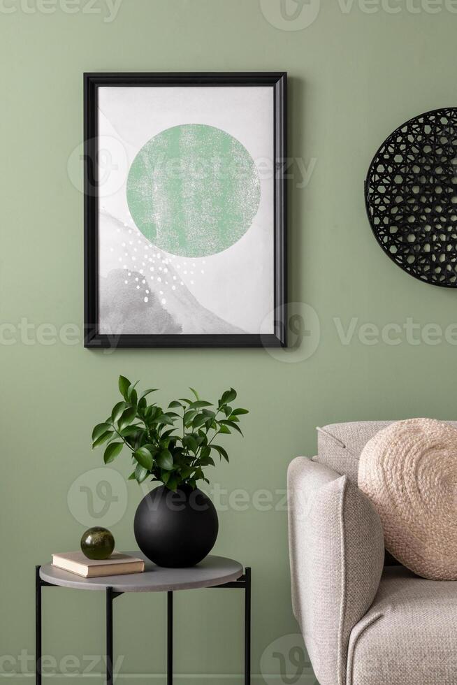 The stylish composition at living room interior with green wall, design sofa, coffee table, ornament on the wall and elegant personal accessories. Mock up poster. Cozy apartment. Template. photo
