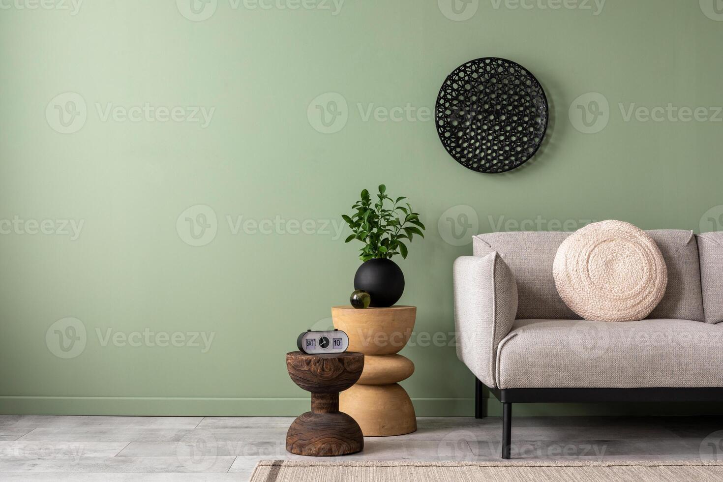 The stylish composition at living room interior with green wall, design sofa, coffee table, ornament on the wall and elegant personal accessories. Copy space. Cozy apartment. Template. photo