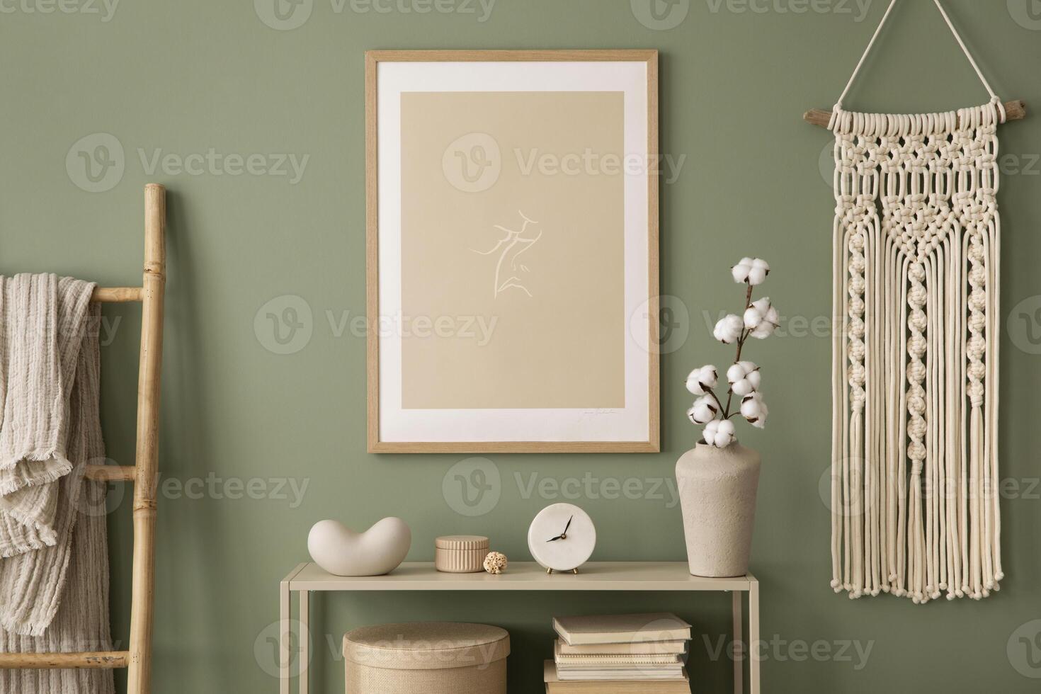 Stylish living room interior design with mock up poster frames, macrame, wooden chest of drawers, beige vase and creative home accessories. Sage green wall. Template. photo