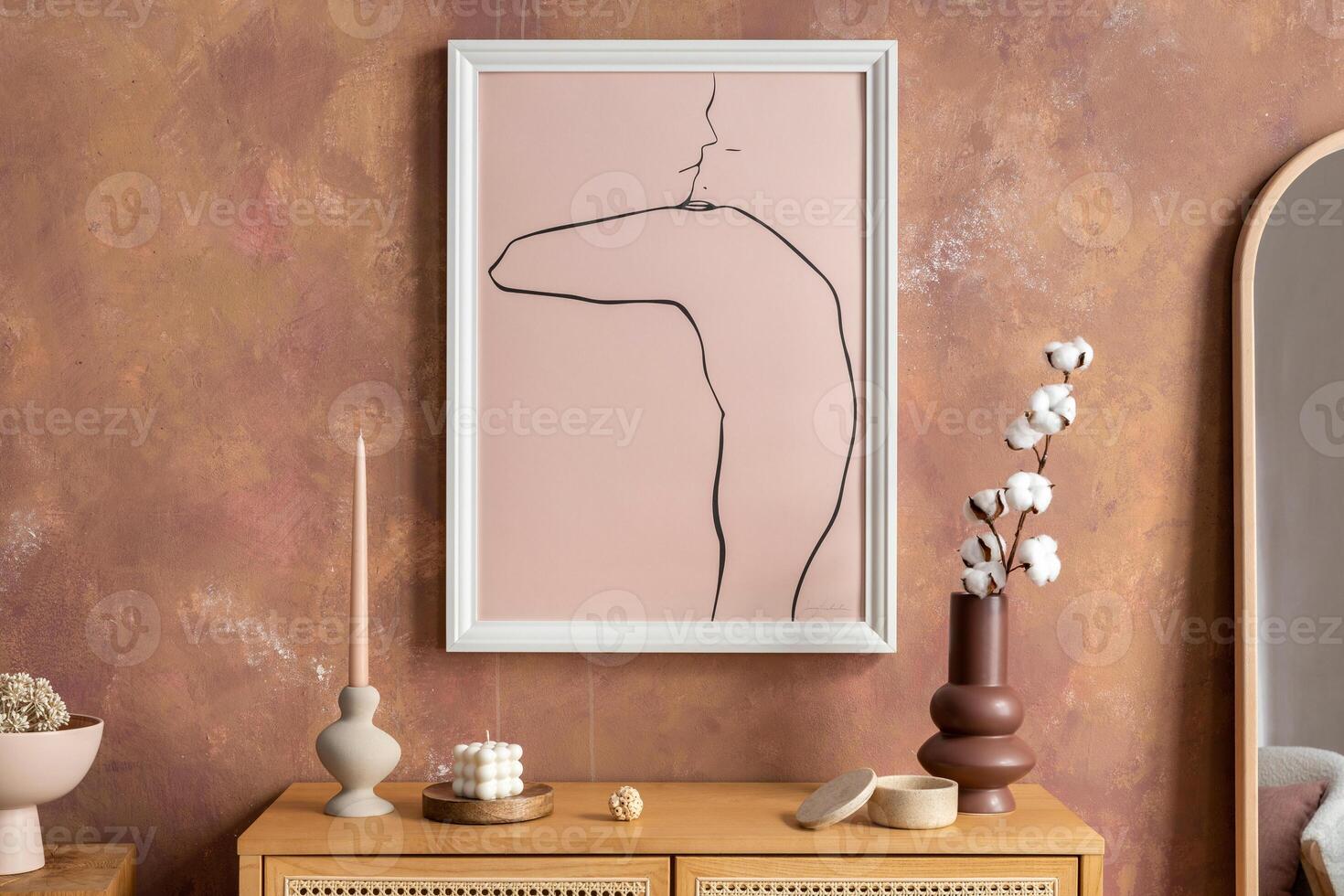 Creative composition vintage living room with rattan chest of drawers, vase, candlestick with candle, miror and minimalistic poster. Stylish accessories. Mock up poster. Template. photo