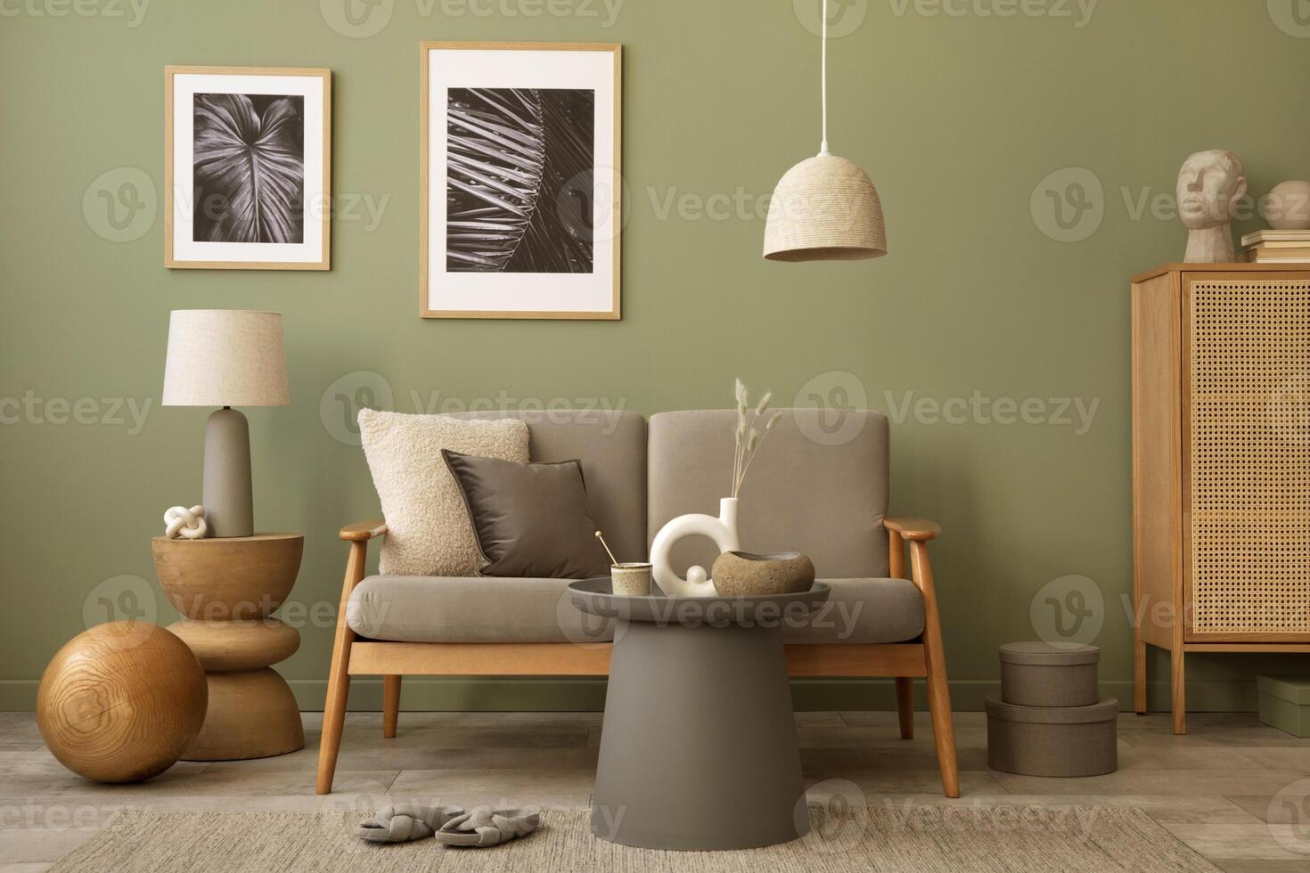 Elegant composition of living room interior. Modern scandi sofa, design pillows, side table, rattan commode and creative personal accessories. Sage green wall. Template. Copy space. photo