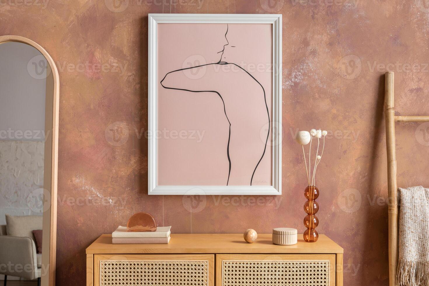 Creative composition vintage living room with rattan chest of drawers, plaid, candlestick with candle, miror and minimalistic poster. Stylish accessories. Mock up poster. Template. photo