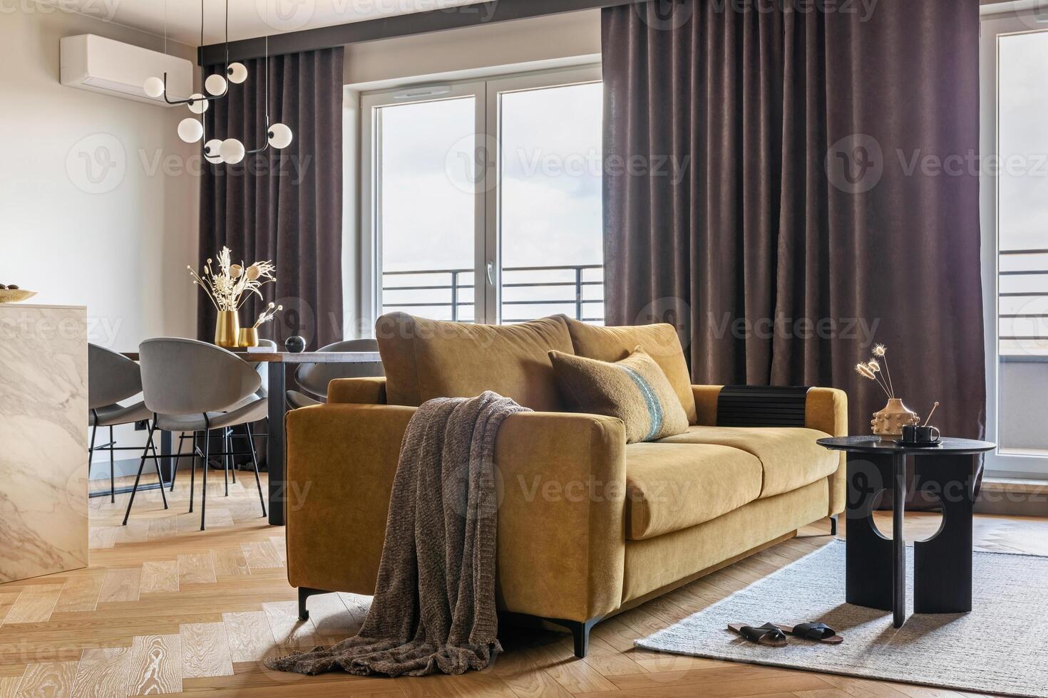 Creative and modern open space interior design with yellow sofa, grey carpet and coffe table . Grey carpet on the herringbone parquet with coffe table, brown curtain in windows. Template. photo