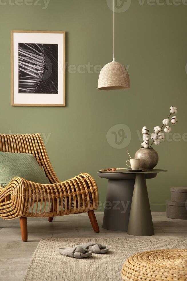 Stylish living room interior design with rattan chair, mock up potser frame, side table and creative accessories. Sage green wall. Template. Copy space. photo