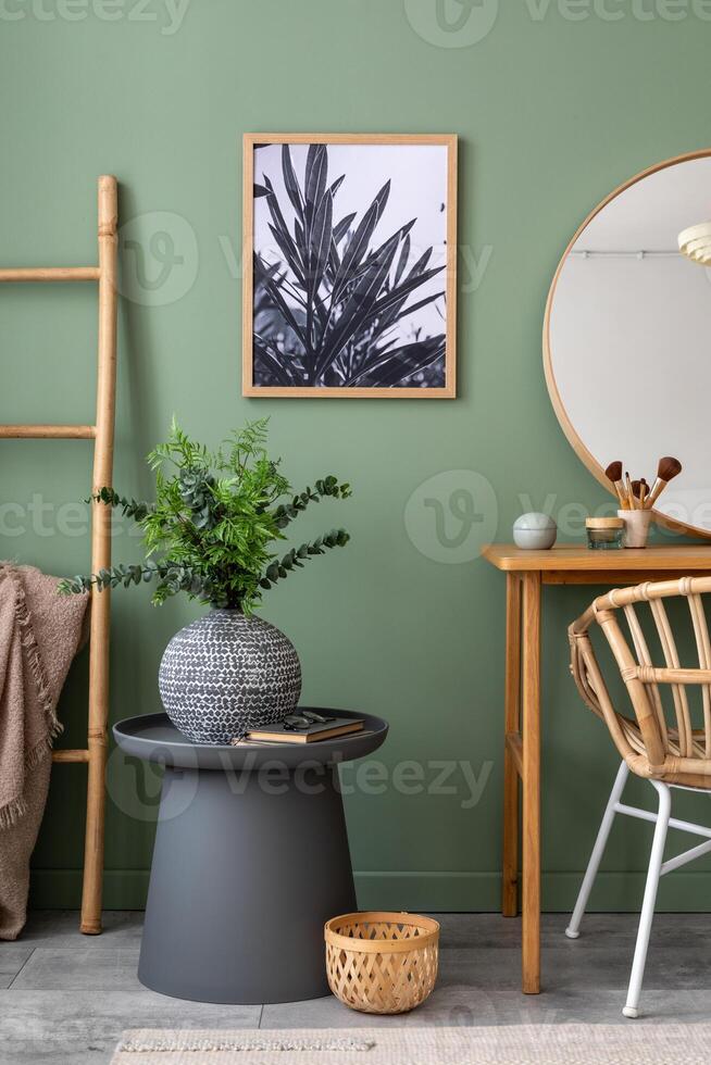 Elegant details of modern interior design with poster in coffe table, round mirror, plant and stylish personal accessories. Wooden vanity table. Mock up poster. Template. photo