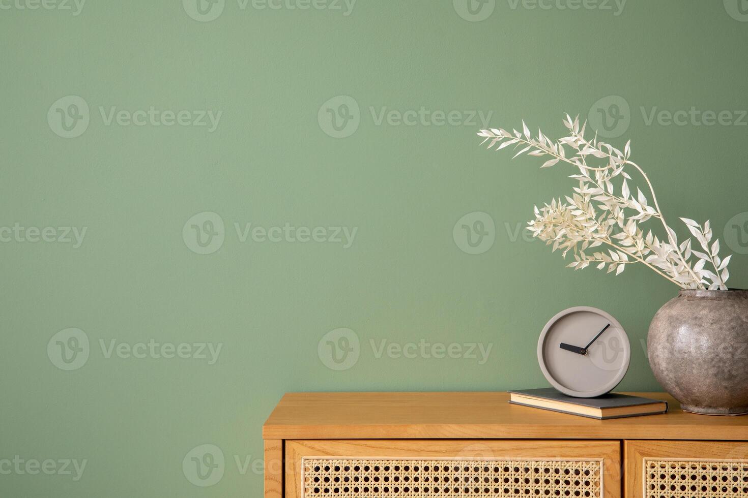 Creative bedroom interior composition with rattan commode, modern home decorations and personal accessories. Eucalyptus green wall. Template. Copy space. photo