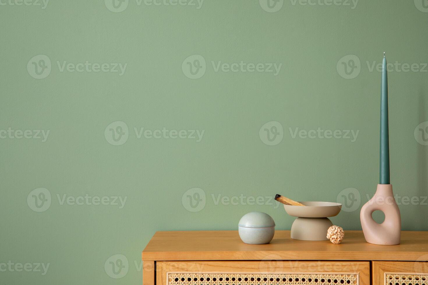 Creative bedroom interior composition with rattan commode, modern home decorations and personal accessories. Eucalyptus green wall. Template. Copy space. photo