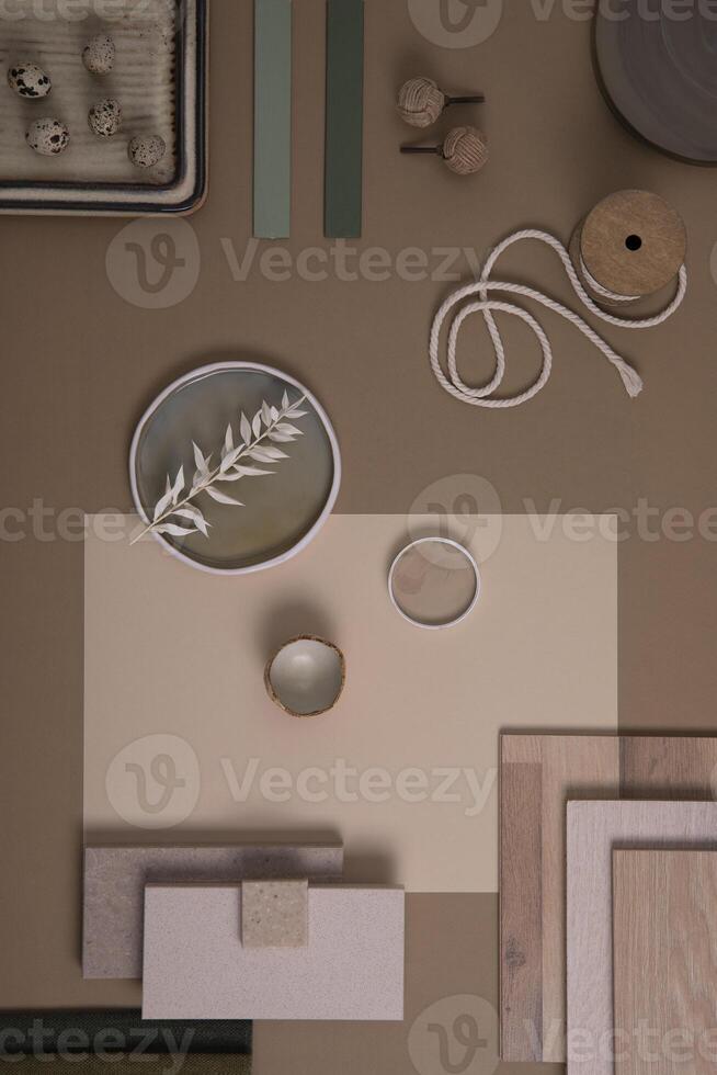 Creative flat lay composition of interior designer moodboard with textile and paint samples, panels and tiles. Beige, brown and green color palette. Copy space. Template. photo
