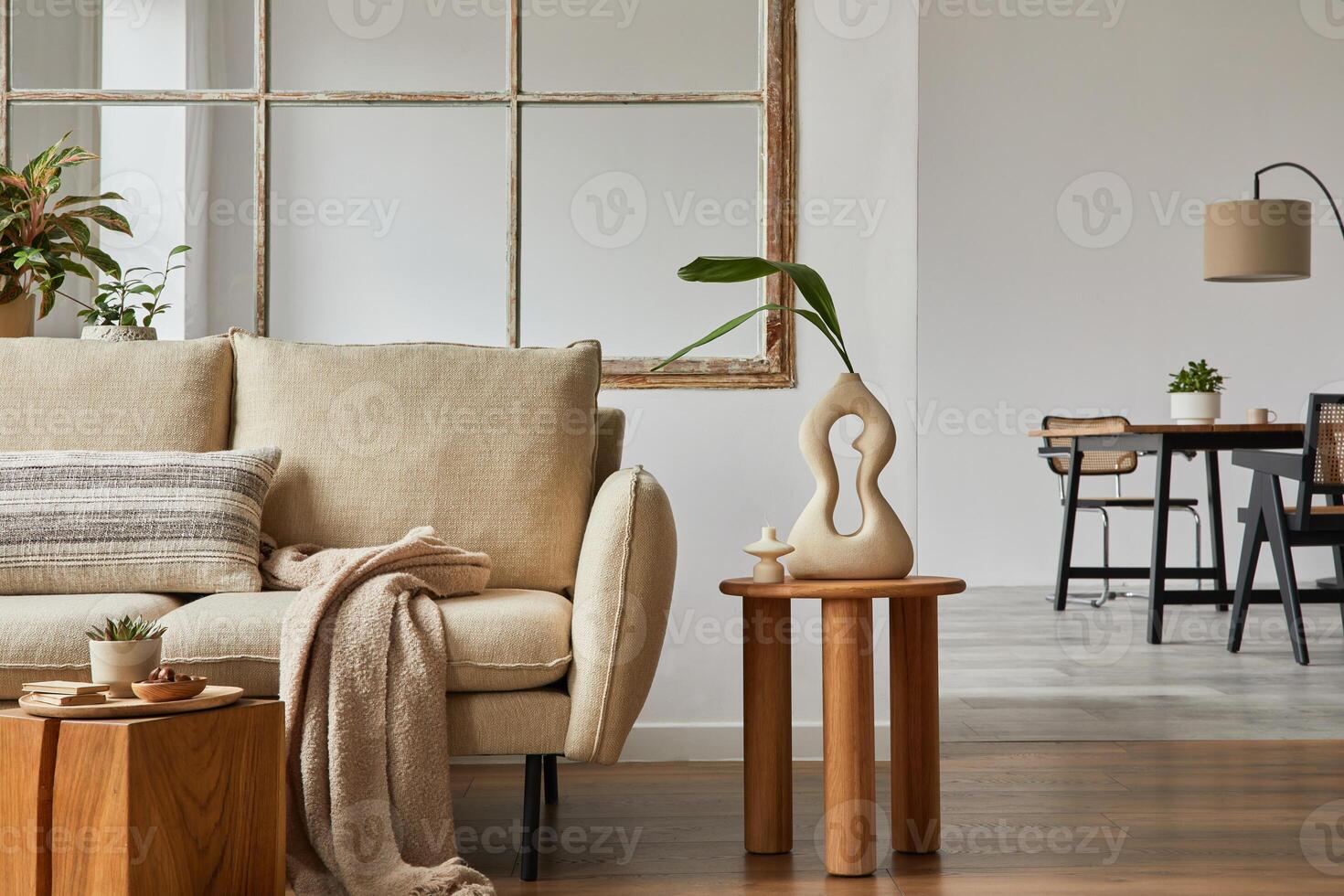 Modern living room interior design with beige sofa, wooden side table, plants and creative accessories. Template. Copy space Dining room in the background. photo