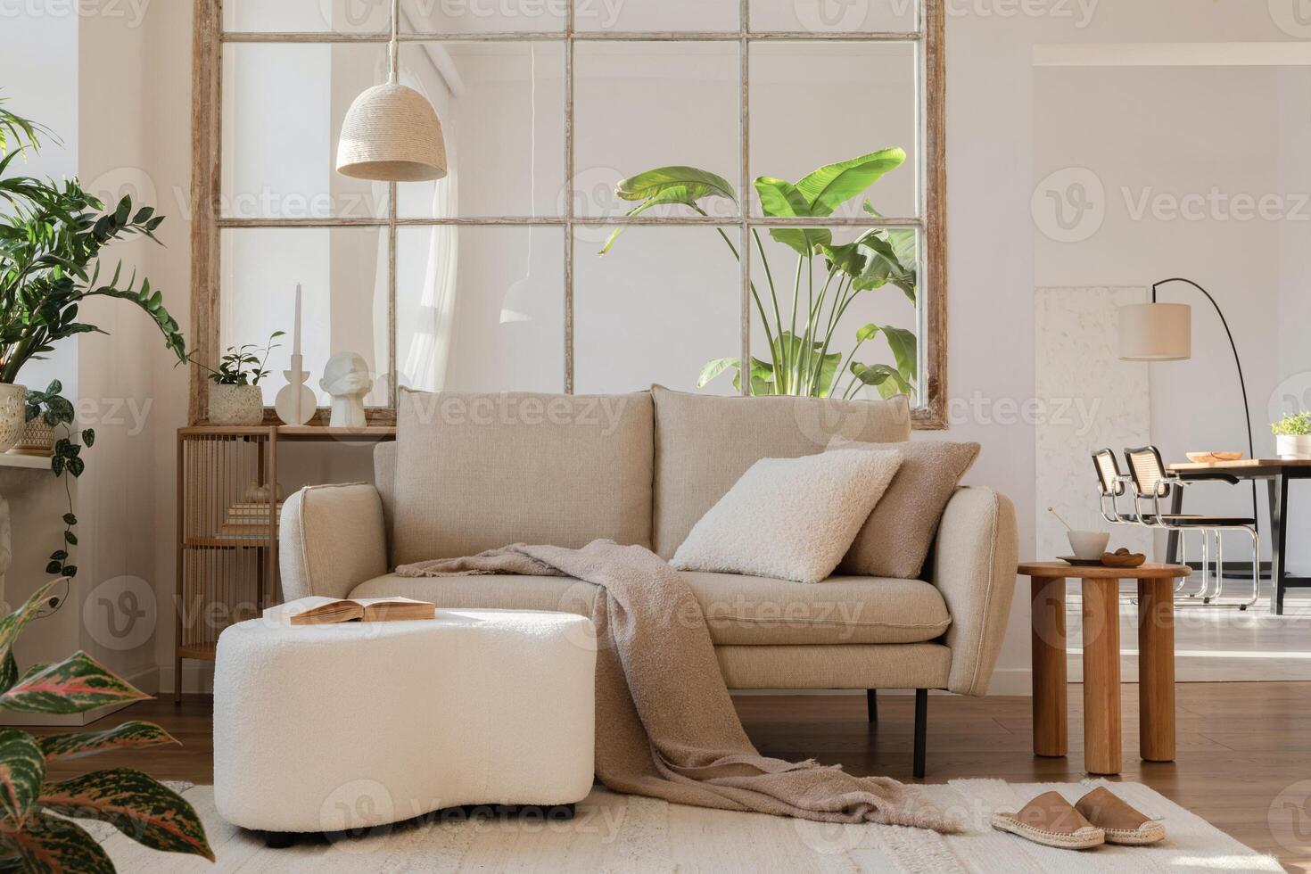 Modern living room interior composition with beige sofa, wooden coffee table and elegant home accessories. Template. Copy space. Dining room in the background. photo