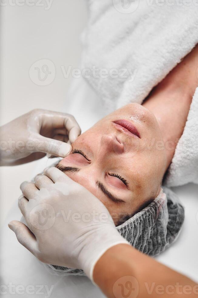 Relaxing facial treatment at a spa with a client receiving care photo