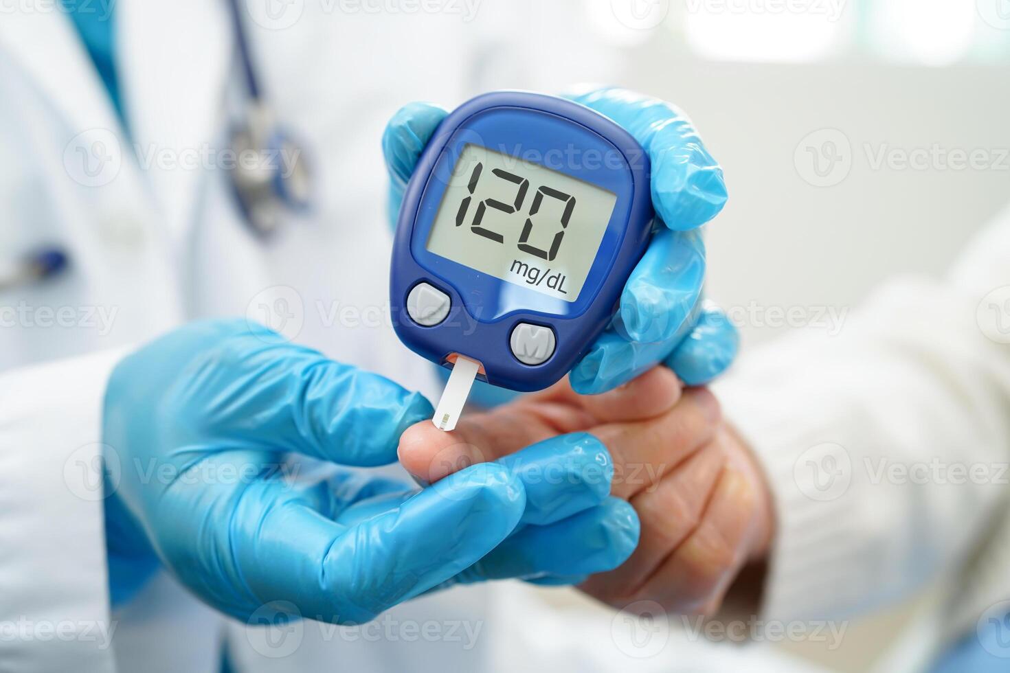 Asian doctor using digital glucose meter for check sample blood sugar level to treatment diabetes. photo
