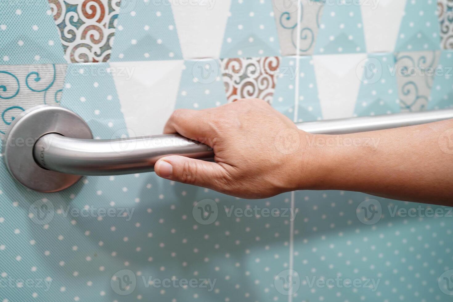 Asian elderly old woman patient use toilet support rail in bathroom, handrail safety grab bar, security in nursing hospital. photo
