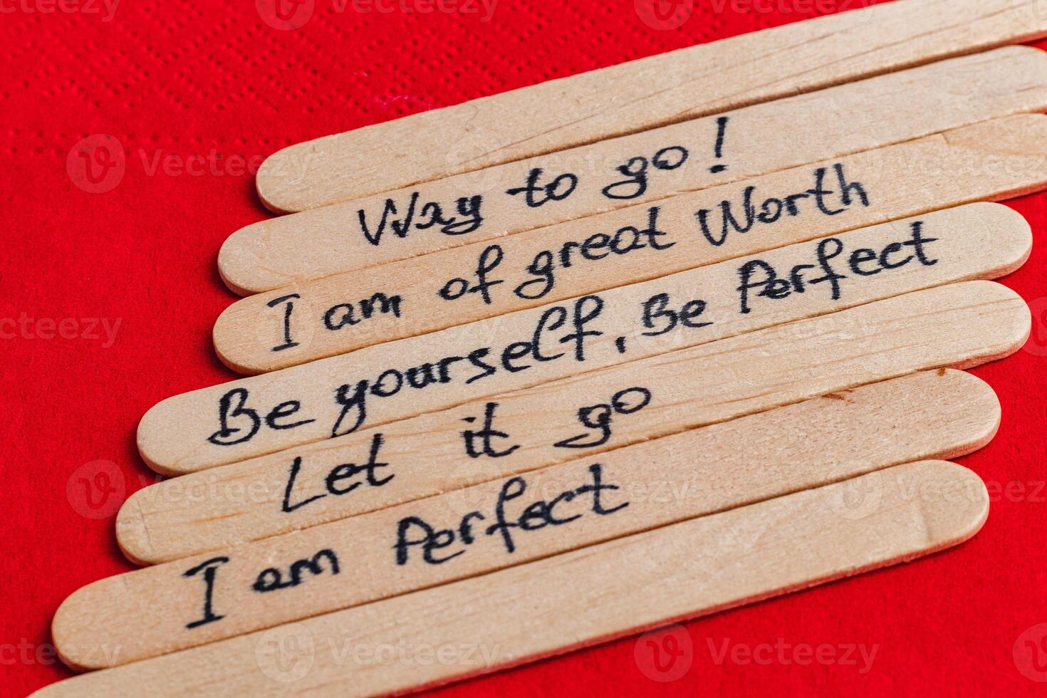 Positive thoughts for increasing self-esteem on wooden posts on red background photo