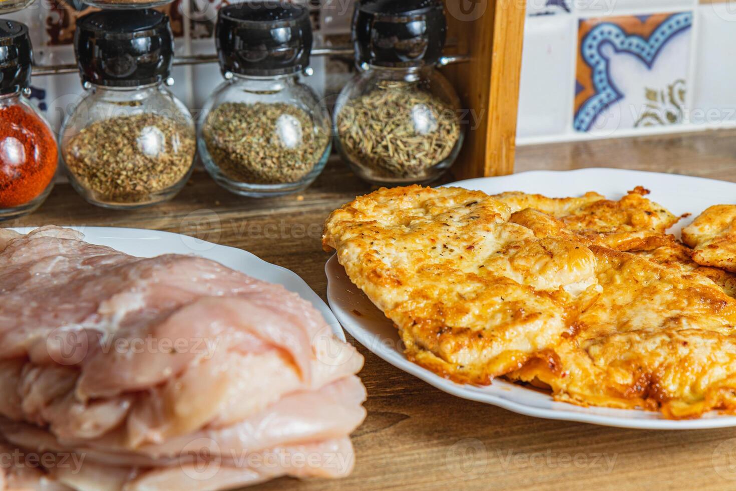 the process of cooking chicken chops with already fried chops in the background photo