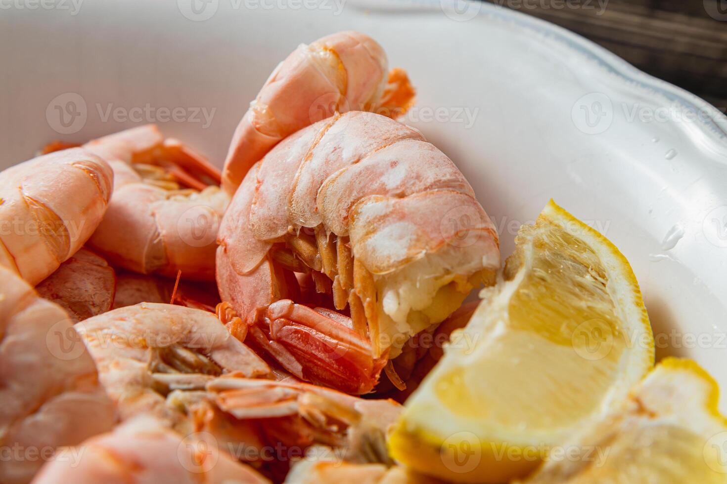 Tiger king prawns cooked and seasoned with lemon, on a wooden table photo