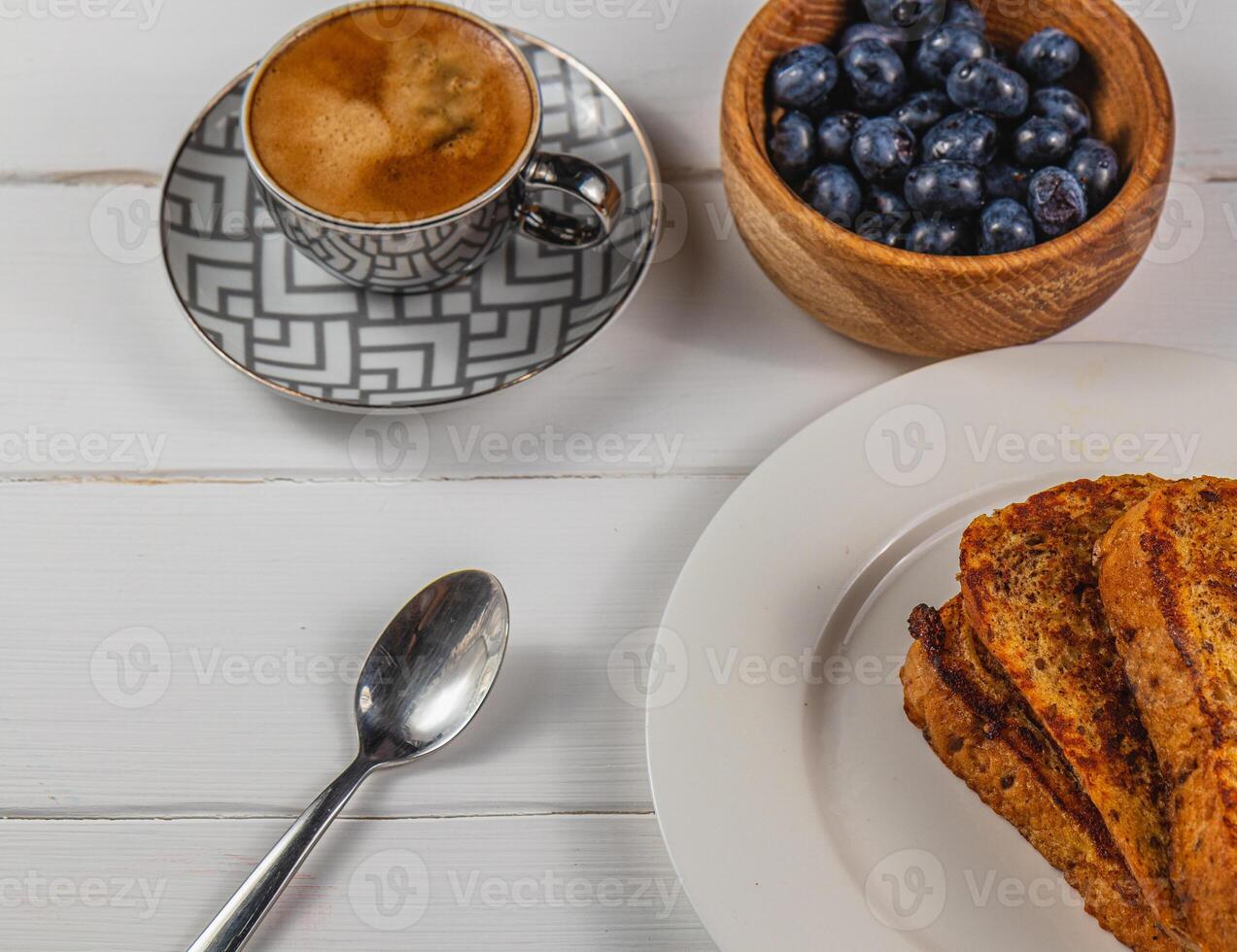 French toast on a white plate with blueberries and coffee for breakfast photo