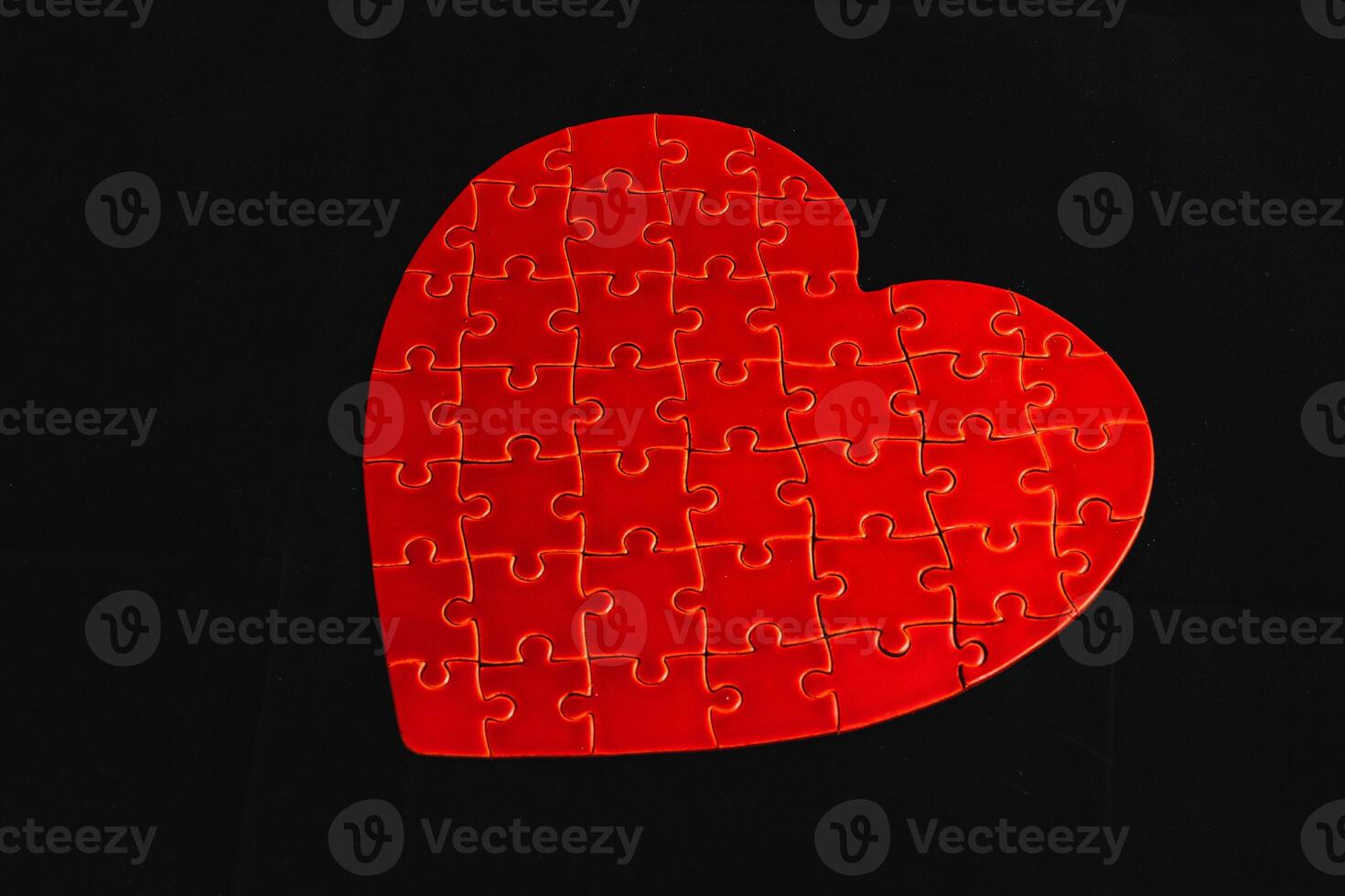Conceptual photo of puzzle, heart shape for Valentine's Day on black background