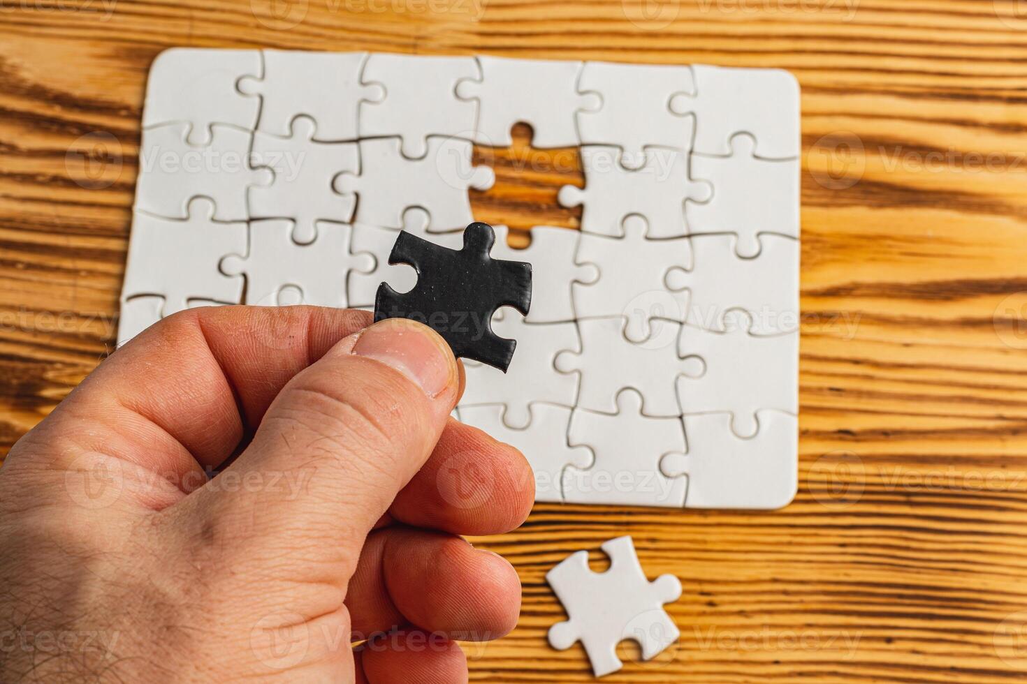 Hands holding black and white puzzle, concept of difficult option choice photo
