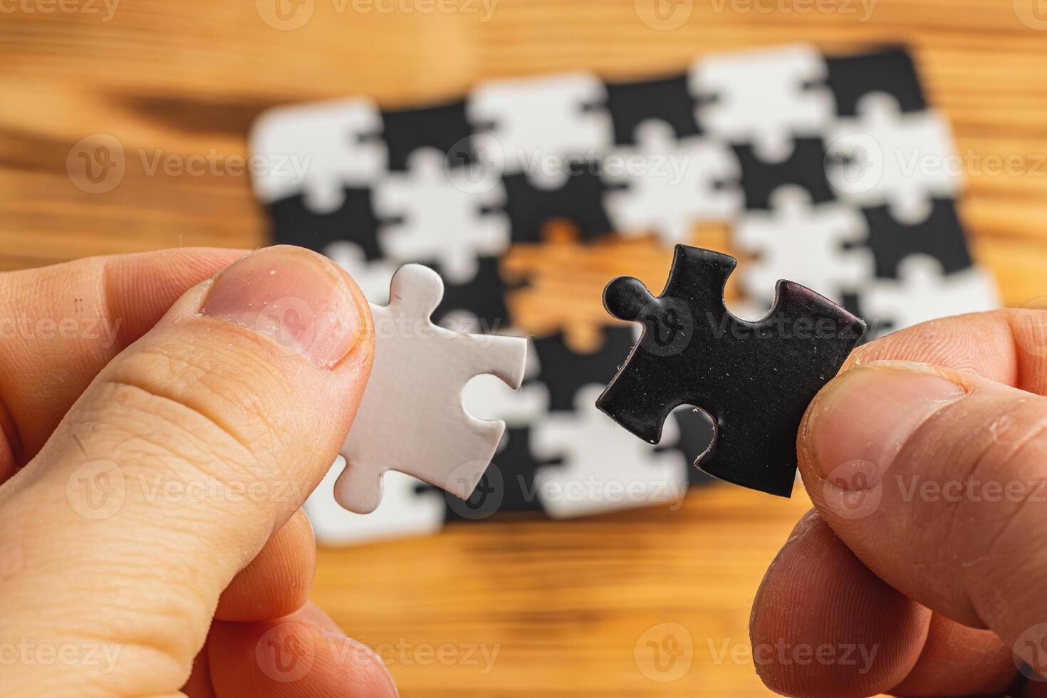 Hands holding black and white puzzle, concept of difficult option choice photo