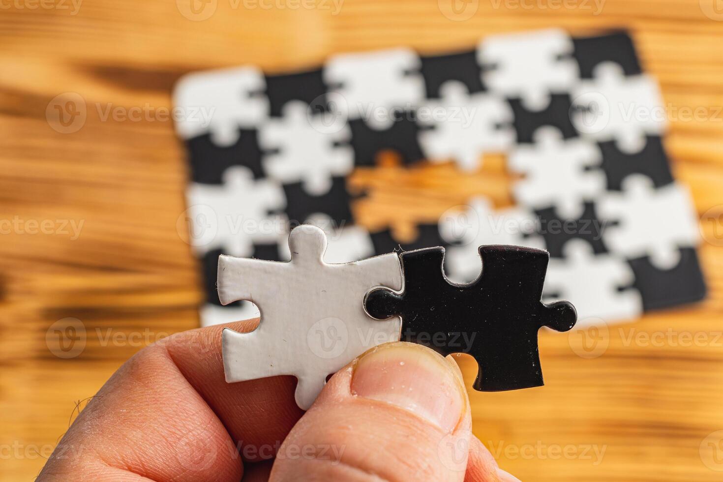 Hands holding black and white puzzle, concept of difficult option choice photo