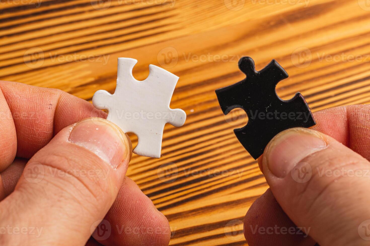 Hands holding black and white puzzle, concept of difficult option choice photo