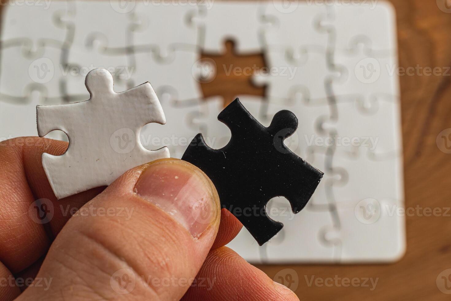 Hands holding black and white puzzle, concept of difficult option choice photo