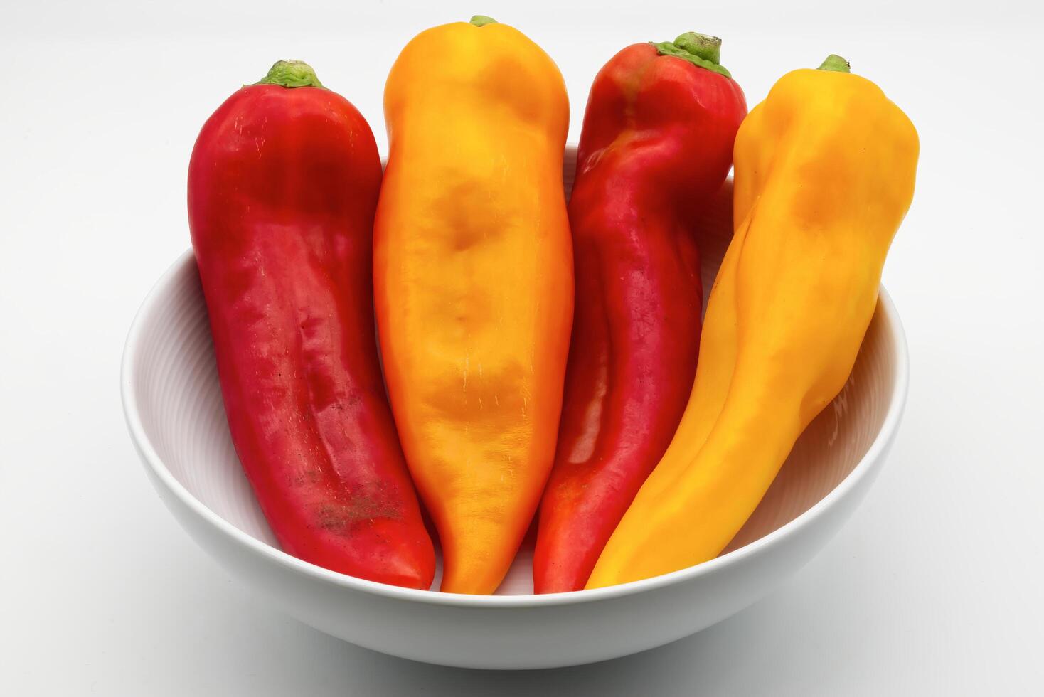 Vibrant Red and Yellow Peppers in a White Bowl photo