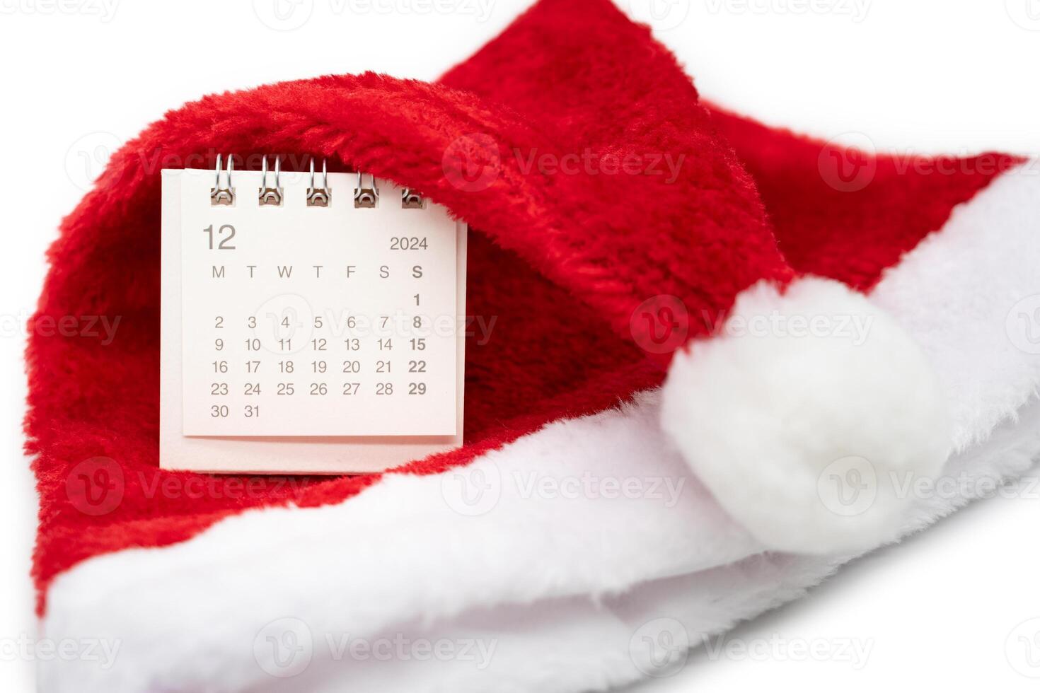 Simple desk calendar for DECEMBER 2024 with Santa hats on white background. New year Calendar concept with copy space. 2024 DEC calendar. photo
