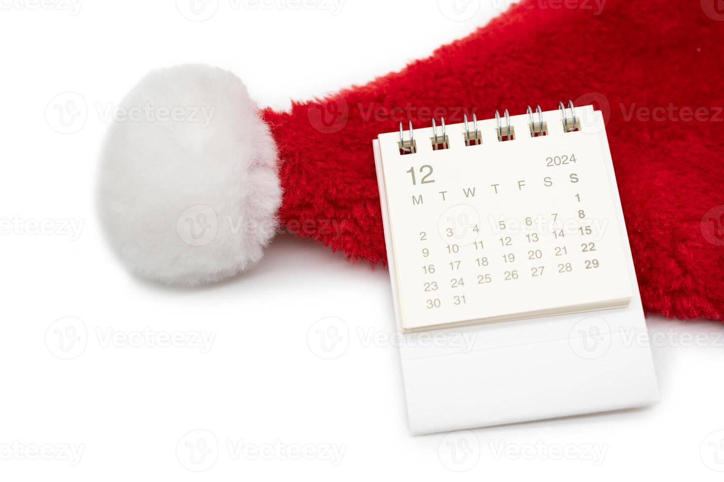 Simple desk calendar for DECEMBER 2024 with Santa hats on white background. New year Calendar concept with copy space. 2024 DEC calendar. photo