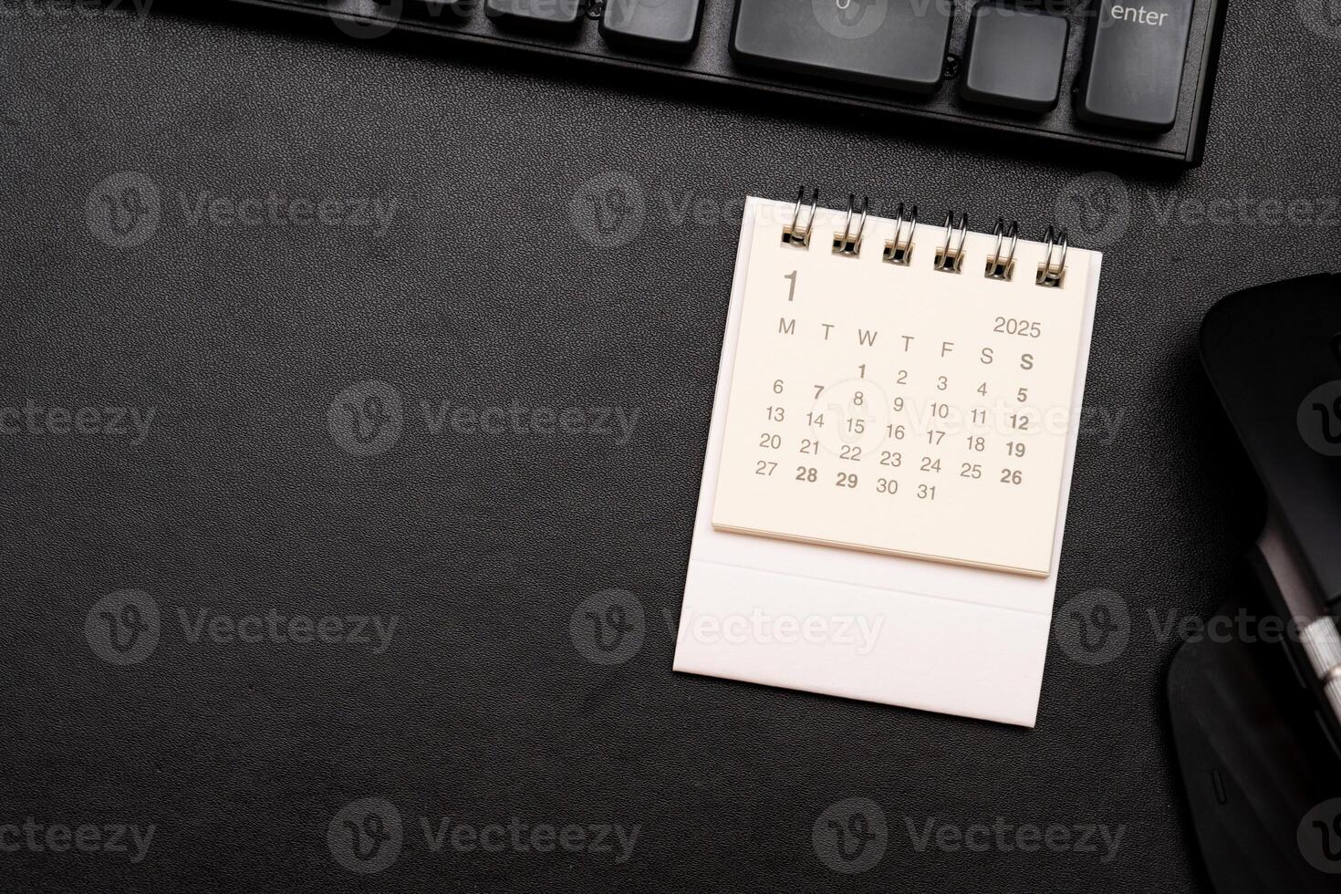Simple desk calendar for January 2025 on desk with office supplies. Calendar concept with copy space. 2025 JAN calendar. photo